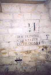 Plaque de rue + indication de nivellement (en bas) + numéro de rue avec son épure au fusain